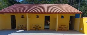 a yellow building with chairs and tables in it at Pousada Araújo em Paraty in Paraty