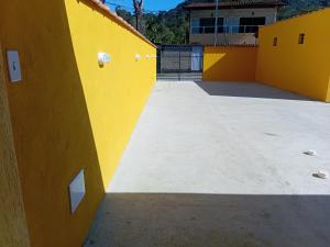an empty courtyard of a house with yellow walls at Pousada Araújo em Paraty in Paraty