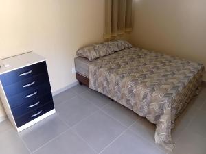 a small bedroom with a bed and a dresser at Pousada Araújo em Paraty in Paraty +5 photos