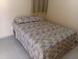 a bed with a comforter and pillows in a bedroom at Pousada Araújo em Paraty in Paraty