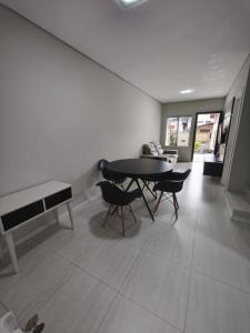 un salon avec une table, des chaises et un canapé dans l'établissement Casa de temporada, à Joinville