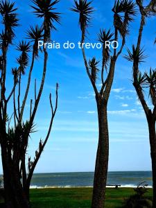 Grupa palm na plaży z napisem Praia do TVe w obiekcie Temporada na Praia do Trevo - Rio das Ostras, RJ w mieście Rio das Ostras