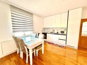 a dining room with a white table and chairs at Ideal for families or friends in Prizren +9 photos