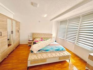 a bedroom with a bed in a room with a window at Ideal for families or friends in Prizren