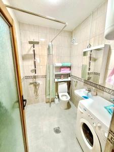 a bathroom with a washing machine and a toilet at Ideal for families or friends in Prizren