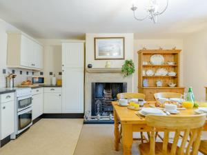 a kitchen with a wooden table and a fireplace at 2 Bed in Rothbury 74811 in Rothbury