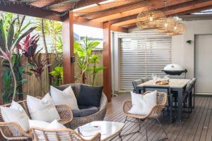 a patio with wicker chairs and a table on a deck at La Luna - Oceanstays in Lennox Head