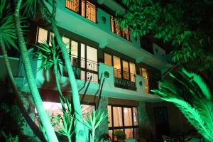 a building with palm trees in front of it at B&B Il Giardino Delle Meraviglie in Melito di Porto Salvo