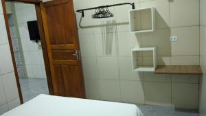 a room with a bed and a door and a shower at Apartamento aconchegante in Marabá