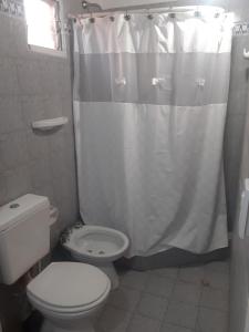 a bathroom with a toilet and a shower curtain at El Coco in Puerto Madryn
