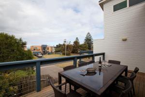 a wooden deck with a table and chairs on a balcony at Beach holiday in Tomakin