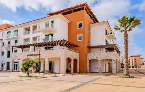 a building with a palm tree in front of it at Aurora D Sal, Beach House in Santa Maria