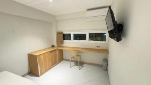 a room with a desk with a tv and a stool at Yado Living in Karanganyar