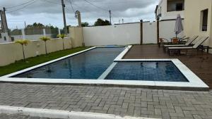 a swimming pool in a backyard with a table and chairs at Casa em Village Barra do Jacuipe in Camaçari