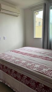 a bed in a bedroom with a window at Casa em Village Barra do Jacuipe in Camaçari
