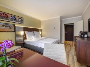una habitación de hotel con una cama y un escritorio en Mercure Hotel Duisburg City, en Duisburg