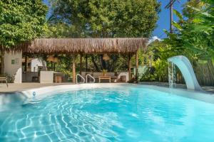 a swimming pool with a waterfall and a pavilion at POUSADA CARMELITHA in Trancoso