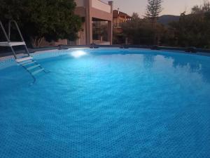 a blue swimming pool with a chair in it at Hector's Studios in Alikanas