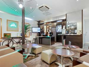 a restaurant with tables and chairs and a counter at ibis Styles Paris République Le Marais in Paris