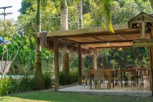 a wooden pergola with a table and chairs at POUSADA CARMELITHA in Trancoso