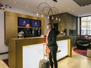 una mujer parada en un bar con su equipaje en Mercure Wien Zentrum, en Viena