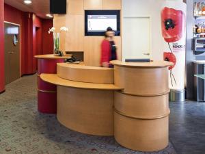 Una mujer parada en un mostrador en un restaurante en ibis Metz Centre Gare, en Metz