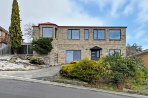 a brick house with windows on a street at Large House, Centrally Located With Amazing Views in Lenah Valley