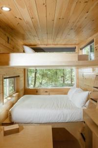 a bed in a wooden room with a window at Postcard Cabins Mount Adams 