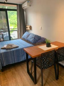 um quarto com uma cama e uma mesa e uma mesa e cadeiras em Pousada Ecoblue Container em Palhoça