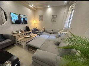 una sala de estar con un sofá y una mesa en Bougainvilier, en Mohammedia
