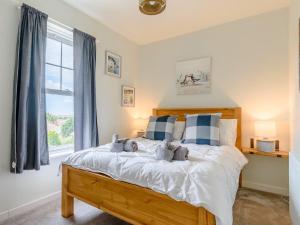 a bedroom with a bed with blue and white pillows at 4 Bed in Bexhill on Sea 77602 in Bexhill