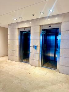two elevators in an office building with blue lights at Terrazas del Puerto Suites in Buenos Aires +27 photos