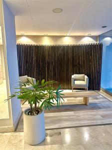 a lobby with a chair and a potted plant at Terrazas del Puerto Suites in Buenos Aires