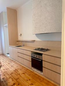 a kitchen with wooden cabinets and a stove top oven at Beach Bungalow Henley - 4 minute walk to the Beach in Henley Beach