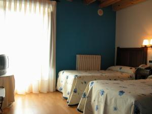 um quarto com 2 camas e uma janela em C.T.R. Camino de la Fuentona em Cabrejas del Pinar