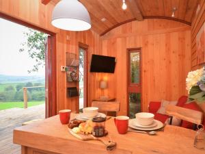 a wooden cabin with a table with food on it at 1 Bed in Bickleigh 53296 in Cadeleigh