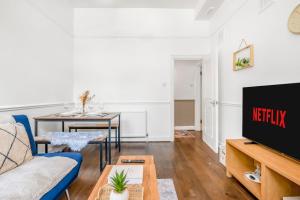 a living room with a couch and a tv at Modern 2BR Flat-Terrace-Free Parking-Rail Station in Croydon