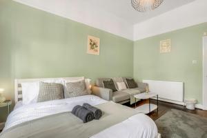 a bedroom with a large bed and a couch at Modern 2BR Flat-Terrace-Free Parking-Rail Station in Croydon