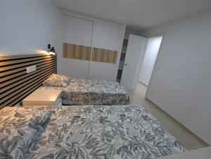 a bedroom with two beds and a closet at Apartamentos Anau k & L- Playa del inglés - Yumbo in Playa del Ingles