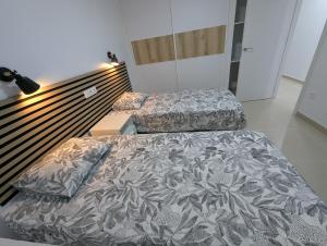 two twin beds in a room with a bedskirts at Apartamentos Anau k & L- Playa del inglés - Yumbo in Playa del Ingles