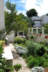 a garden with white flowers and a fence at Apartments by the sea Podgora, Makarska - 2615 in Podgora