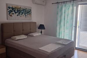 a large bed in a bedroom with a window at Apartments by the sea Podgora, Makarska - 2615 in Podgora
