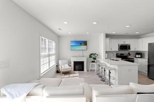 a white living room with white couches and a kitchen at Brand-New 3BR-3BA Family Home in Little River - All King Beds Minutes to NMB & ICW in Cherry Grove Beach