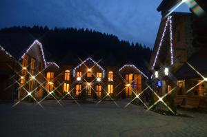 uma casa decorada com luzes de Natal à noite em Sribni Rosy em Mykulychyn