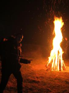 a man holding a gun in front of a fire at Sribni Rosy in Mykulychyn
