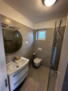a bathroom with a sink and a toilet and a mirror at Apartments with parking space Medulin - 2274 in Medulin +42 photos