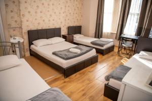 a room with three beds and a piano at The Crystal Lodge Hotel in Croydon