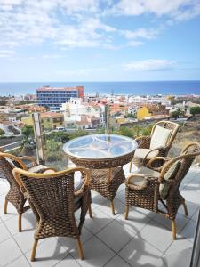 a table and chairs on a balcony with a view at Modern Panoramic Villa with Pool & Terrace in Puerto de la Cruz