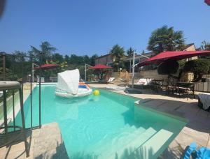 - une piscine avec un bateau dans l'eau dans l'établissement Chambre d'hôte Petit déjeuner, Sauna et Piscine inclus Jacuzzi en option, à Sarlat-la-Canéda