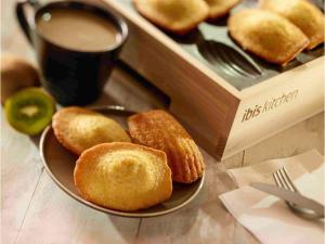 a plate with donuts on a table with a cup of coffee at ibis Reims Tinqueux in Reims
